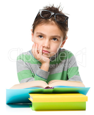 Young boy is daydreaming while reading book