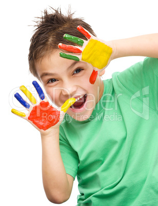 Portrait of a cute boy playing with paints