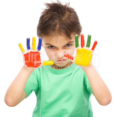 Portrait of a cute boy playing with paints