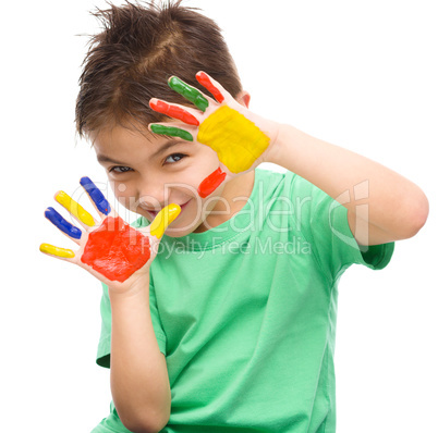 Portrait of a cute boy playing with paints