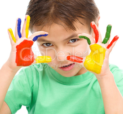 Portrait of a cute boy playing with paints