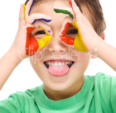 Portrait of a cute boy playing with paints