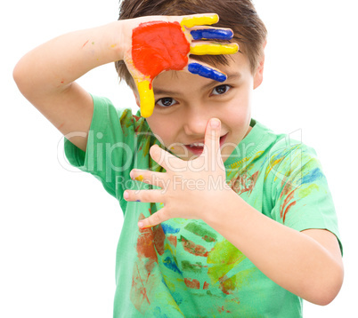 Portrait of a cute boy playing with paints