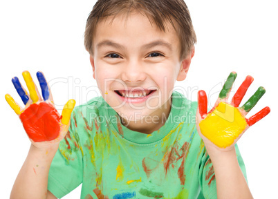 Portrait of a cute boy playing with paints