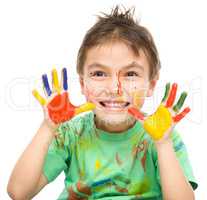 Portrait of a cute boy playing with paints