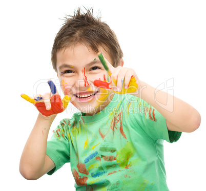 Portrait of a cute boy playing with paints