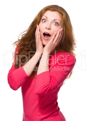 Woman is holding her face in astonishment