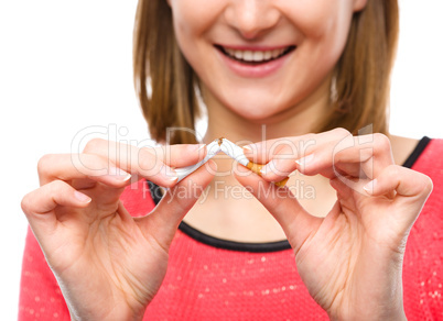 Young woman is breaking a cigarette