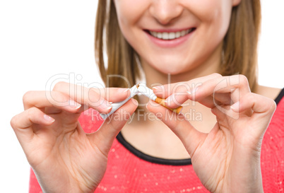 Young woman is breaking a cigarette