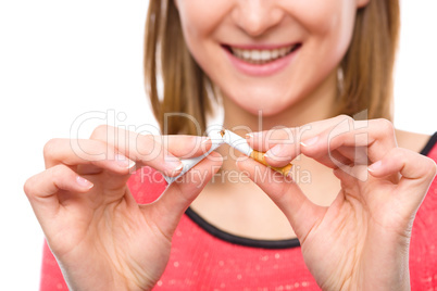 Young woman is breaking a cigarette