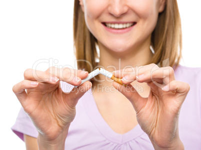 Young woman is breaking a cigarette