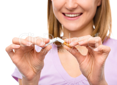 Young woman is breaking a cigarette