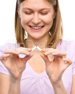 Young woman is breaking a cigarette