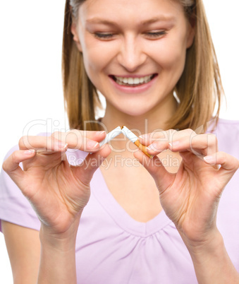 Young woman is breaking a cigarette