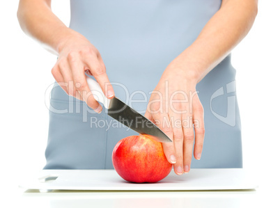 Cook is chopping red apple