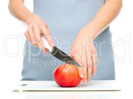 Cook is chopping red apple