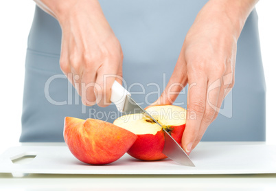 Cook is chopping red apple