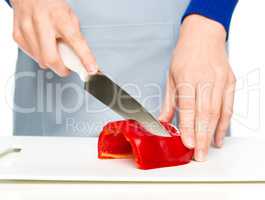 Cook is chopping bell pepper