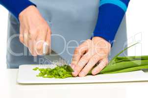 Cook is chopping green onion