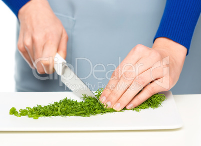 Cook is chopping green dill