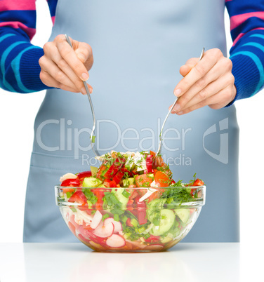 Cook is mixing salad
