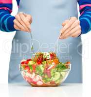 Cook is mixing salad