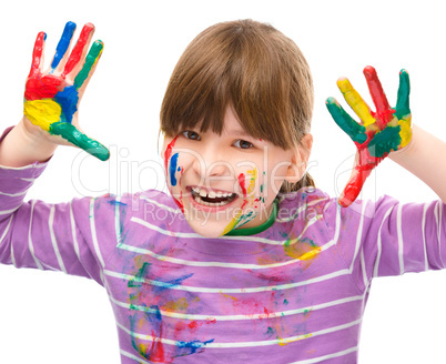 Portrait of a cute girl playing with paints