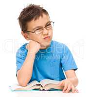 Little boy is tired to read his book