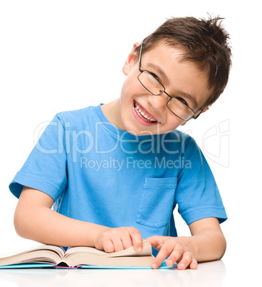 Little boy is reading a book