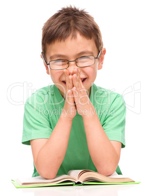 Little boy is reading a book