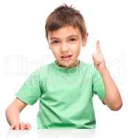 Little boy is pointing up using his index finger