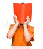 Little boy is hiding behind a book