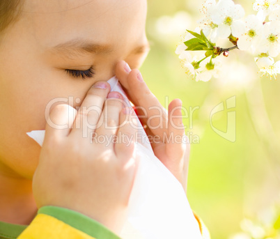 Little girl is blowing her nose