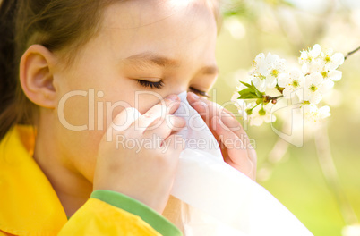 Little girl is blowing her nose