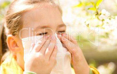 Little girl is blowing her nose