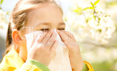Little girl is blowing her nose