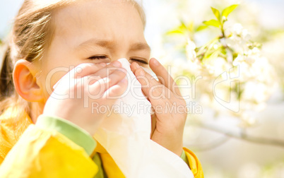 Little girl is blowing her nose