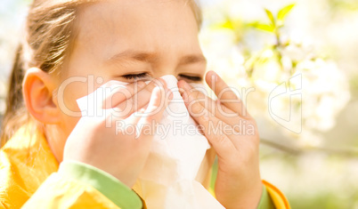 Little girl is blowing her nose