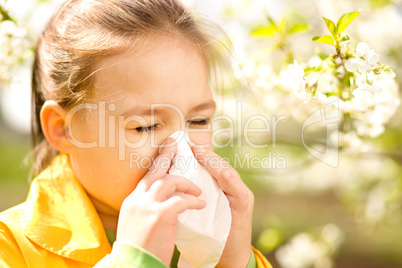 Little girl is blowing her nose