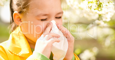 Little girl is blowing her nose