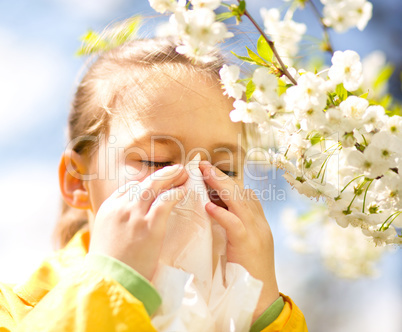 Little girl is blowing her nose