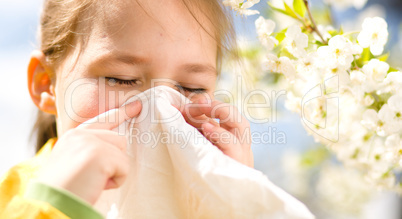 Little girl is blowing her nose