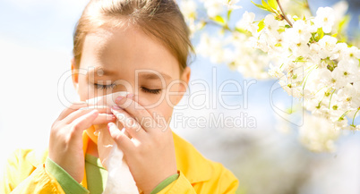 Little girl is blowing her nose