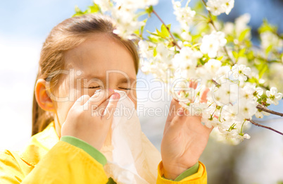 Little girl is blowing her nose