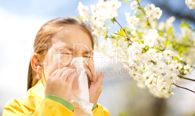 Little girl is blowing her nose