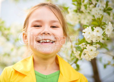 Portrait of a little girl near tree in bloom