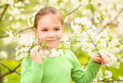 Portrait of a little girl near tree in bloom