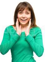 Woman is holding her face in astonishment