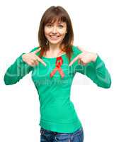 Woman is pointing to the red awareness ribbon
