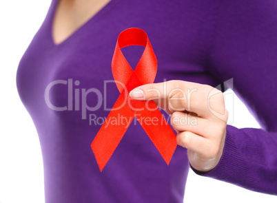 Woman is holding the red awareness ribbon